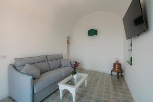 a living room with a couch and a table at Villa Nettuno in Positano