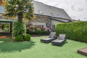 a yard with two chairs and a palm tree at VILLA KER BLEUENN * 10 PERSONNES * PISCINE * SAUNA in La Fresnais