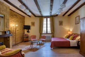 a room with a bed and a couch and a table at Les Flamboyants in Sarlat-la-Canéda