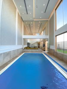 a large swimming pool in a room with a large window at شاليه المنى - الخبر - للعائلات in Al Khobar