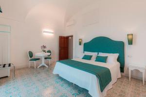 a bedroom with a large bed with a green headboard at Villa Nettuno in Positano