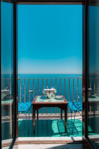 a balcony with a table and a view of the ocean at Villa Nettuno in Positano