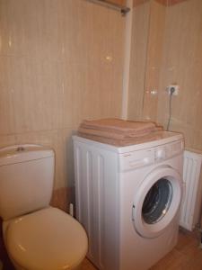 a white washing machine and a toilet in a bathroom at Sapera Evdokia in Filiatra