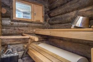 a log cabin bathroom with a bench and a window at Pihlakieppi 1 in Ruka