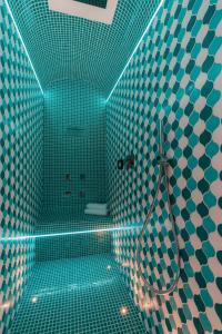 a bathroom with a shower with green tiled walls at Villa Nettuno in Positano