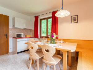 cocina y comedor con mesa de madera y sillas en Katharina en Brixen im Thale