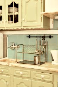 a kitchen sink with a metal rack on the counter at Balili Surf House in Baleal