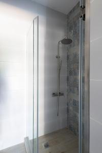 une douche avec une porte vitrée dans une salle de bain dans l'établissement Camara Luxury Apartments (Deluxe Apartment), à Pylos 3 autres photos
