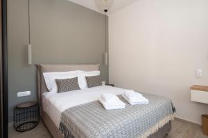 een slaapkamer met een bed met twee handdoeken erop bij Camara Luxury Apartments (Deluxe Apartment) in Pylos