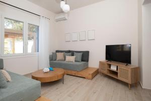 un salon avec un canapé et une télévision à écran plat dans l'établissement Camara Luxury Apartments (Deluxe Apartment), à Pylos