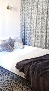 łóżko w sypialni z oknem z zasłonami w obiekcie Apartamenty dobowe w centrum Warszawy w Warszawie