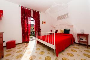 een slaapkamer met een rood bed en een raam bij La Limonaia in Sperlonga