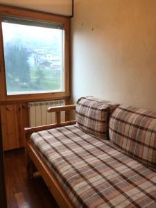 a couch in a room with a window at Finestra sull’Adamello in Passo del Tonale