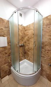 una ducha con puerta de cristal en un baño en Apartamenty dobowe w centrum Warszawy Lok 3, en Varsovia