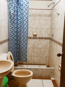 y baño con ducha, aseo y lavamanos. en Hostal Muchik, en Chiclayo
