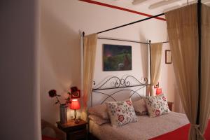 1 dormitorio con cama con dosel y almohadas en B&B Il casale dei gechi, en Poggio Nativo