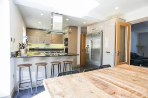 uma cozinha com uma grande mesa de madeira e bancos em Seascape - 4 bed home in Bracklesham Bay em Chichester