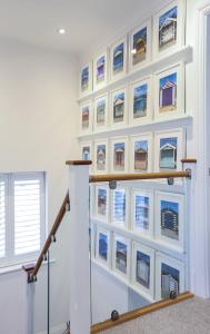a wall of picture frames on a wall in a stair case at Seascape - 4 bed home in Bracklesham Bay in Chichester