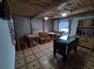 a kitchen and dining room with a table and a piano at Apartmány ANJA in Vysoke Tatry - Tatranska Kotlina