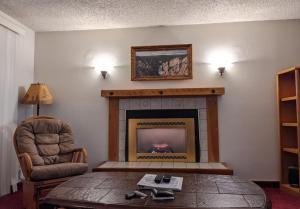 a living room with a fireplace and a chair at GetAways at Timbers at Island Park Village in Island Park +6 photos