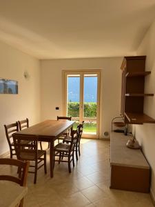 een eetkamer met een tafel en stoelen en een raam bij Lago e Giardino apartment in Bellagio