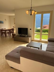 een woonkamer met een bank, een tv en een tafel bij Lago e Giardino apartment in Bellagio