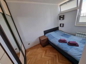 um quarto com uma cama com duas toalhas roxas em Centrum Warszawa - Center of Warsaw em Varsóvia