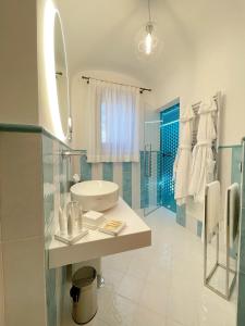 a white bathroom with a sink and a mirror at Villa Nettuno in Positano