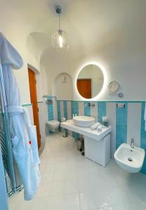 a bathroom with two toilets and a sink and a mirror at Villa Nettuno in Positano