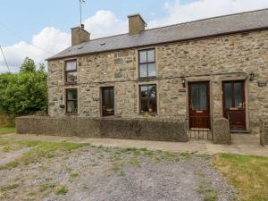 an old stone house with windows and a door at Dwyros in Pwllheli