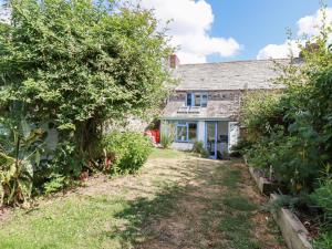 an old stone house with a garden in front of it at Gwynn Cottage in Bodmin