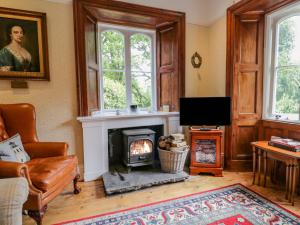 a living room with a fireplace and a tv at Danes Court in Bowland Bridge