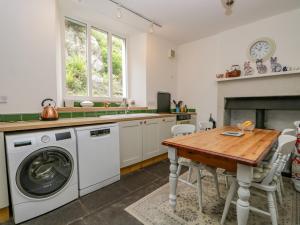 a kitchen with a washing machine and a table at Danes Court in Bowland Bridge