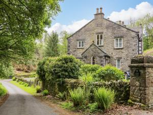 una vieja casa de piedra al lado de una carretera en Danes Court, en Bowland Bridge