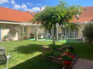 a house with a garden with a tree in the yard at MonPe apartmánik s atmosférou in Komárno