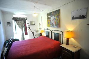 a bedroom with a red bed with a lamp and a window at chevalier claudio in Agnone