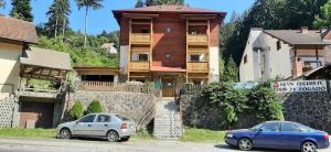 two cars parked in front of a building at Villa Hope (Vila Speranta) in Băile Tuşnad