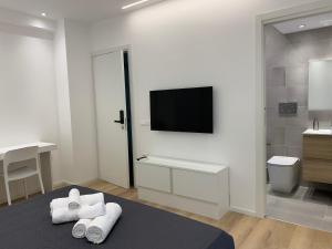 カリアリにあるABBA ROOMSのベッドルーム(テレビ付)、ベッド(タオル付)