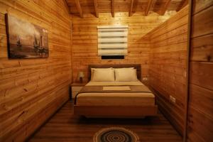 a bedroom with a bed in a wooden room at Bujtina SIAR in Pogradec +52 photos