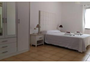 a bedroom with a bed and a dresser with a mirror at Anahi Homes Corralejo- Dracaena 20 in La Oliva