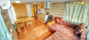 a living room with a couch and a table and a kitchen at Casuta Mobila Miniş in Miniş
