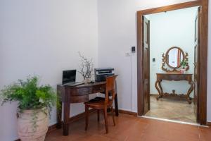 Zimmer mit einem Schreibtisch, einem Computer und einem Spiegel in der Unterkunft SOGNI DA MARE in Tropea