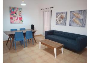 sala de estar con sofá azul y mesa en Anahi Homes Corralejo -Villa Codeso 7, en La Oliva