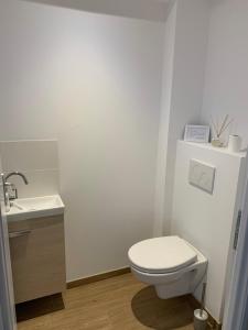 une salle de bains blanche avec toilettes et lavabo dans l'établissement Biby BeachHouse, à Lacanau 17 autres photos