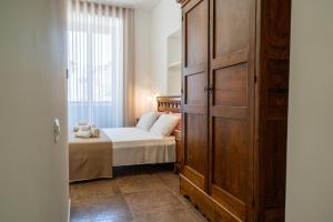 a bedroom with a bed and a large wooden cabinet at SOGNI DA MARE in Tropea