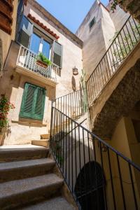 ein altes Gebäude mit einer Treppe und einem Balkon in der Unterkunft SOGNI DA MARE in Tropea