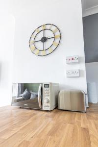 une horloge sur un mur à côté d'une machine dans l'établissement Queen Street Apartments, à Whitehaven