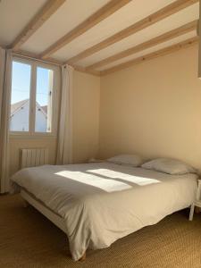 une chambre avec un grand lit et une fenêtre dans l'établissement Biby BeachHouse, à Lacanau