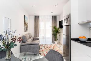 uma cozinha e uma sala de estar com uma mesa de vidro em Quivir Apartamentos Deluxe Casa del Arco em Andújar