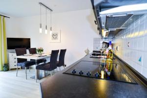 eine Küche mit einer schwarzen Arbeitsplatte und einem Tisch in der Unterkunft Haus Stranddüne DS29 in Cuxhaven